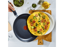 Charger l&#39;image dans la galerie, Omelette dans une poêle sur une planche en bois. Brocolis et tomates visibles.
