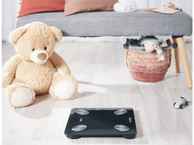 Charger l'image dans la galerie, Balance au sol avec un ours en peluche, un banc et un panier avec une peluche. Cadre clair et aéré.
