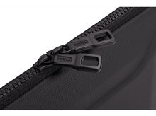 Charger l&#39;image dans la galerie, Gros plan sur des tirettes de fermeture éclair noires avec nom de marque sur une surface noire.
