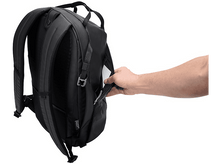 Charger l&#39;image dans la galerie, Sac à dos noir avec une main qui atteint la poche latérale.
