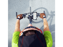 Charger l&#39;image dans la galerie, Vue aérienne d&#39;un cycliste avec téléphone sur le guidon affichant une carte, sur asphalte gris.
