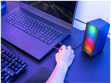 Charger l'image dans la galerie, Ordinateur portable connecté à un haut-parleur avec affichage lumineux coloré sur un bureau.
