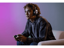 Charger l&#39;image dans la galerie, Homme portant un casque, jouant avec une manette. Fond coloré.
