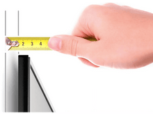 Charger l&#39;image dans la galerie, Une main mesure une surface noire avec un ruban à mesurer jaune sur fond blanc.
