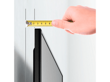 Charger l&#39;image dans la galerie, Une main tient un mètre ruban contre un mur pour mesurer la distance d&#39;installation d&#39;un téléviseur.
