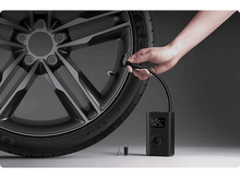 Charger l&#39;image dans la galerie, Gonfleur de pneu noir avec un tuyau noir connecté à un pneu de voiture.
