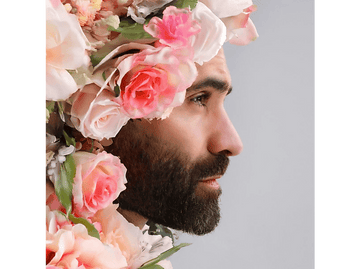 Homme avec une couronne de fleurs. Prise de vue de profil.